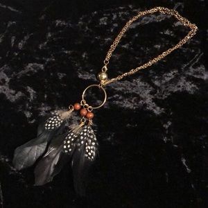 Feather, wood, and gold tone necklace